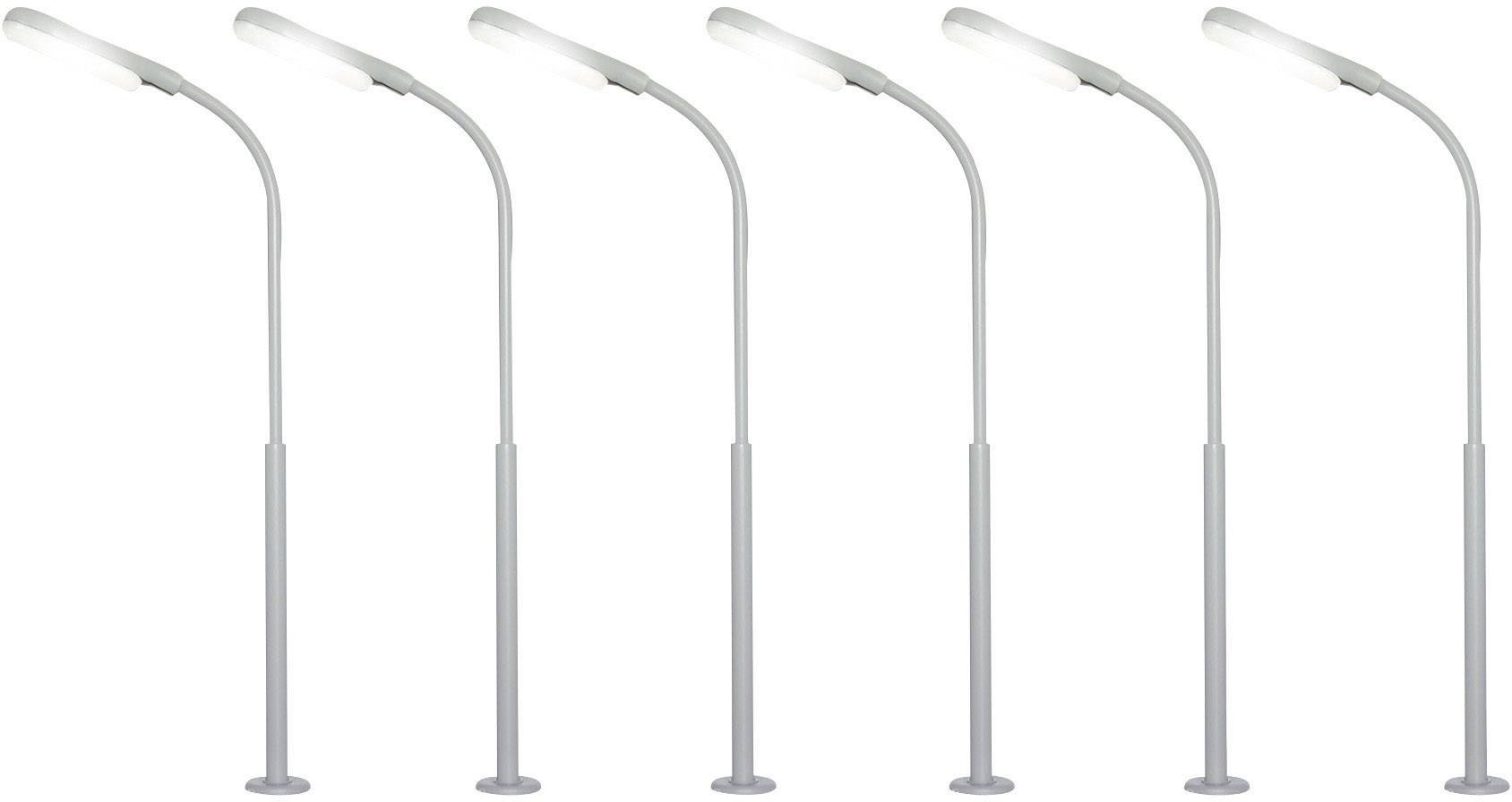 Pět podobných pouličních lamp v řadě, všechny jasně svítí.