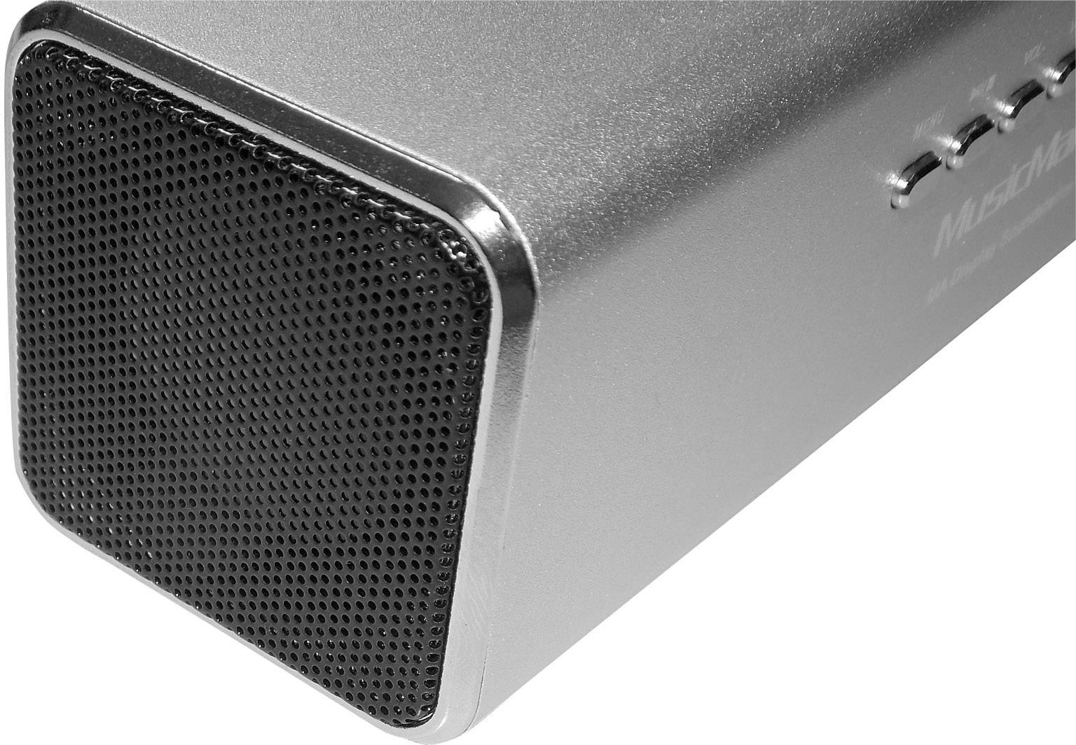 Kovový Bluetooth reproduktor ve stříbrné barvě, zobrazující přední mřížku a boční tlačítka, tmavě šedá mřížka s kulatou texturou.
