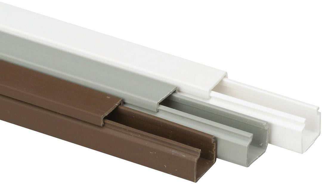 Tři kabelové kanály v bílé, šedé a hnědé barvě, položené vedle sebe. Slouží k organizovanému vedení kabelů.