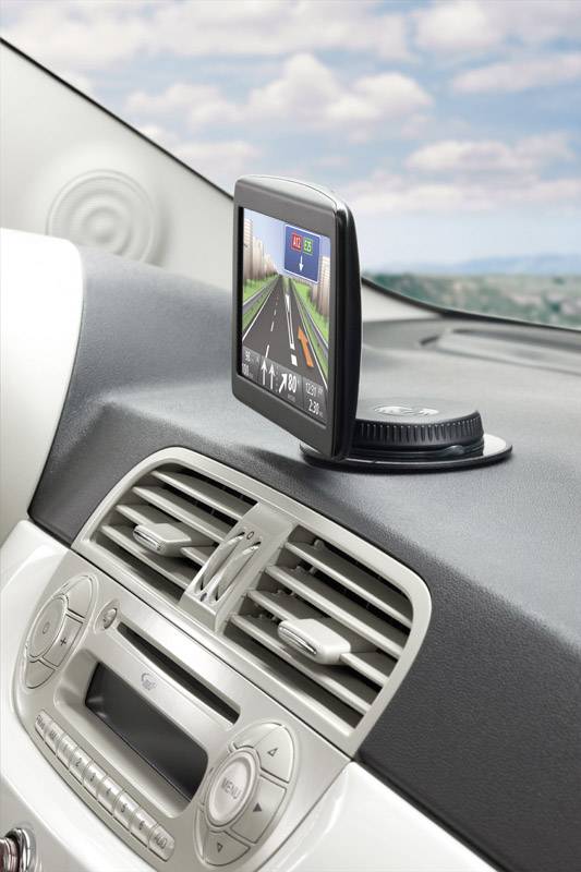 Navigační zařízení na palubní desce automobilu zobrazuje silniční mapu s trasou.