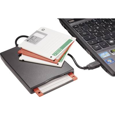 Externí disketová mechanika s několika disketami, připojená k laptopku. Firemní logo viditelné na klávesnici.
