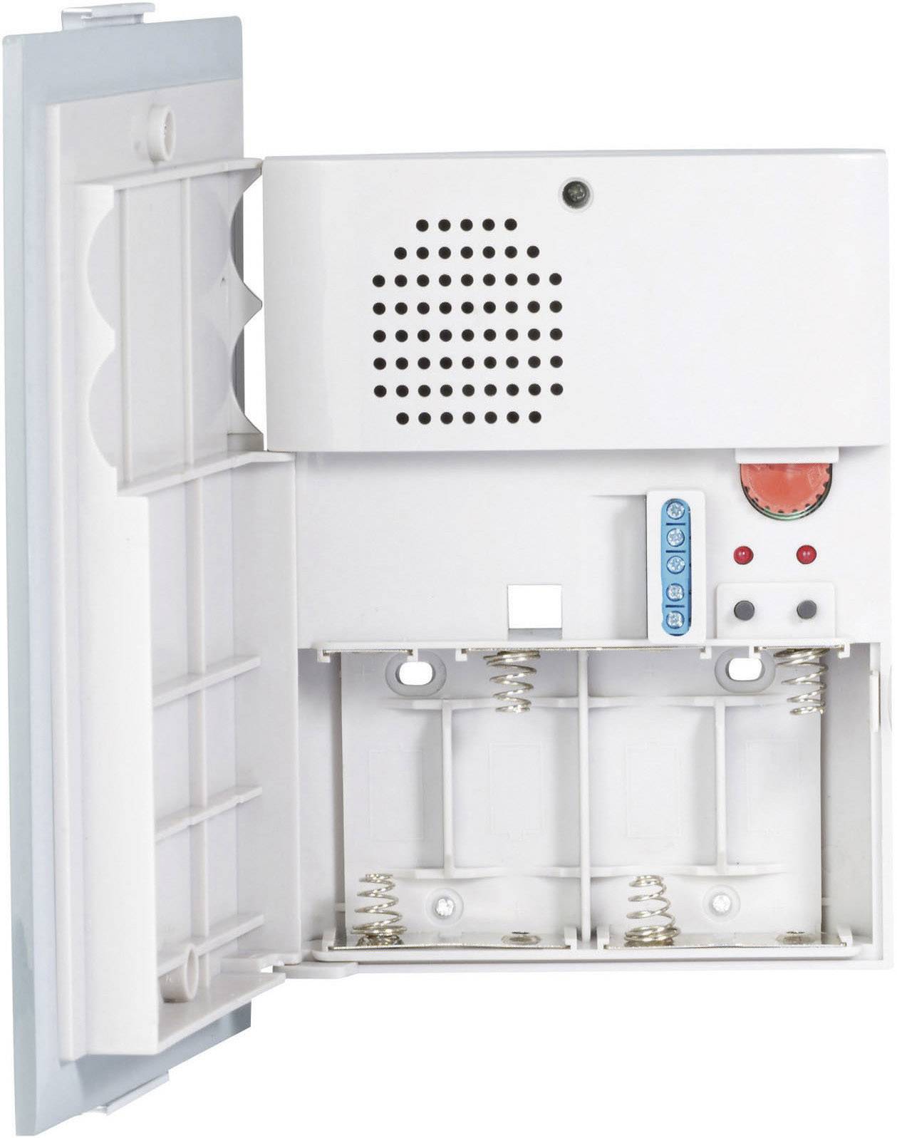 Bílý alarmní nebo komunikační box napájený baterií s otevřeným víkem, třemi místy pro baterie, reproduktorem a viditelným červeným tlačítkem.