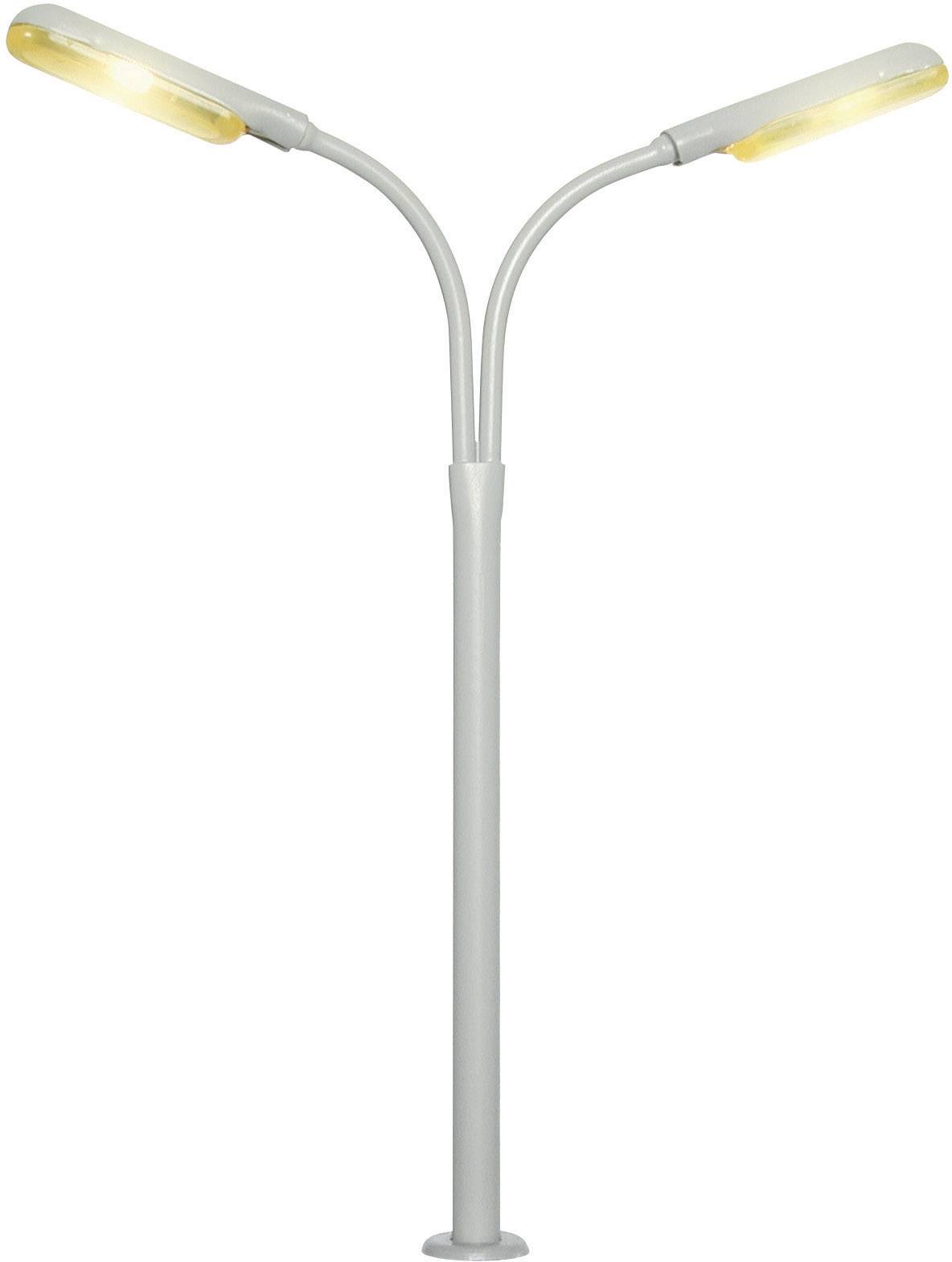 Stříbrná moderní pouliční lampa se dvěma dovnitř zahnutými rameny a svítícími LED lampami vyzařujícími teplé světlo.
