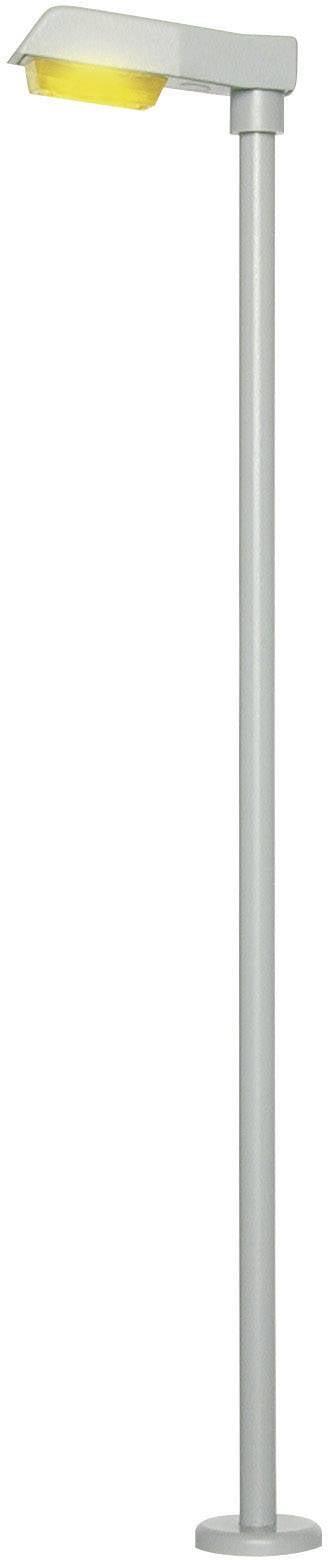 Moderní volně stojící LED pouliční lampa s dlouhým kovovým stožárem a žlutým stínidlem, vhodná pro městské osvětlení.