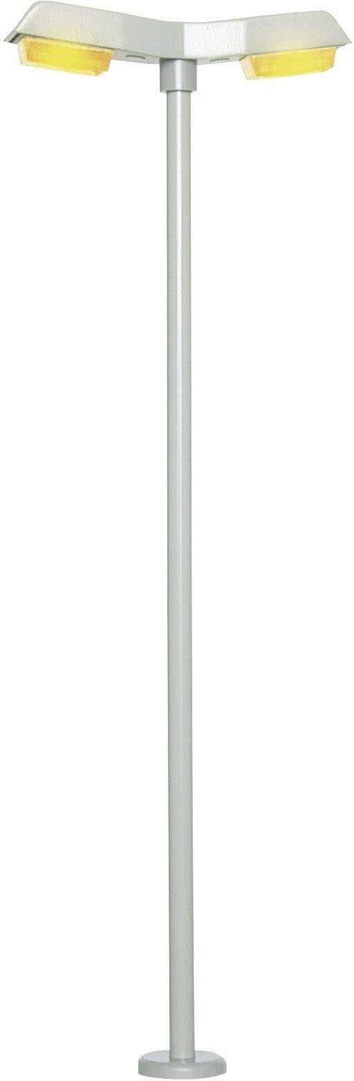 Moderní stojací lampa se dvěma žlutými, nastavitelnými světly na stříbrném, štíhlém podstavci.