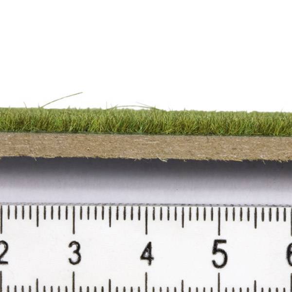 Lineal ukazuje 6 cm dlouhý pruh umělého trávníku z bočního pohledu.