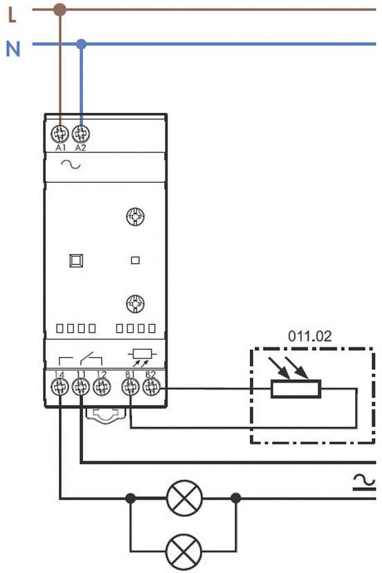 Schematický diagram znázorňuje zapojení relé pro ovládání dvou lamp. Nahoře jsou svorky pro fázový a nulový vodič.