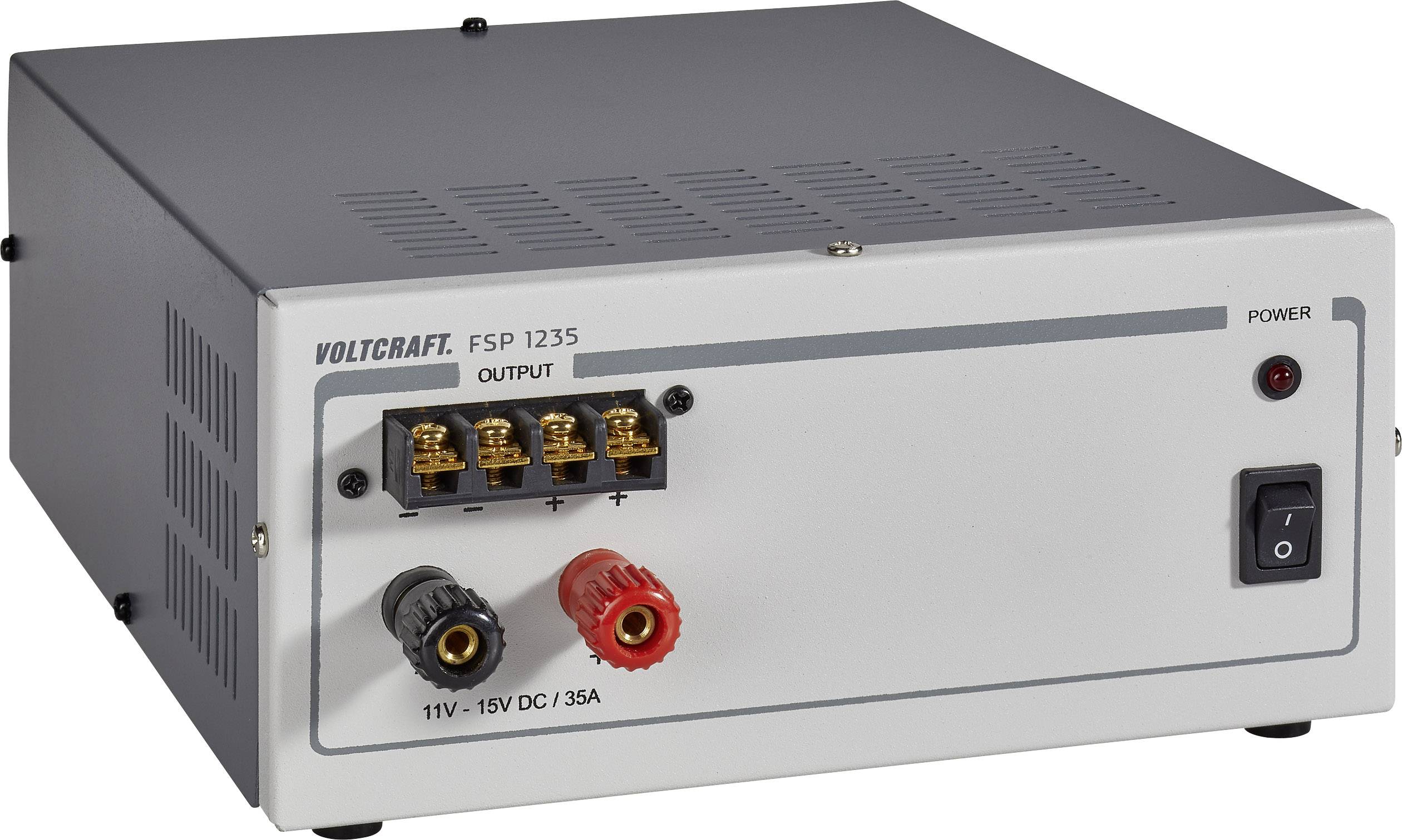 Šedý síťový zdroj s logem Voltcraft. Zobrazuje vstupy pro 11V-15V DC, 35A a síťový vypínač. Vhodný pro elektrická zařízení.
