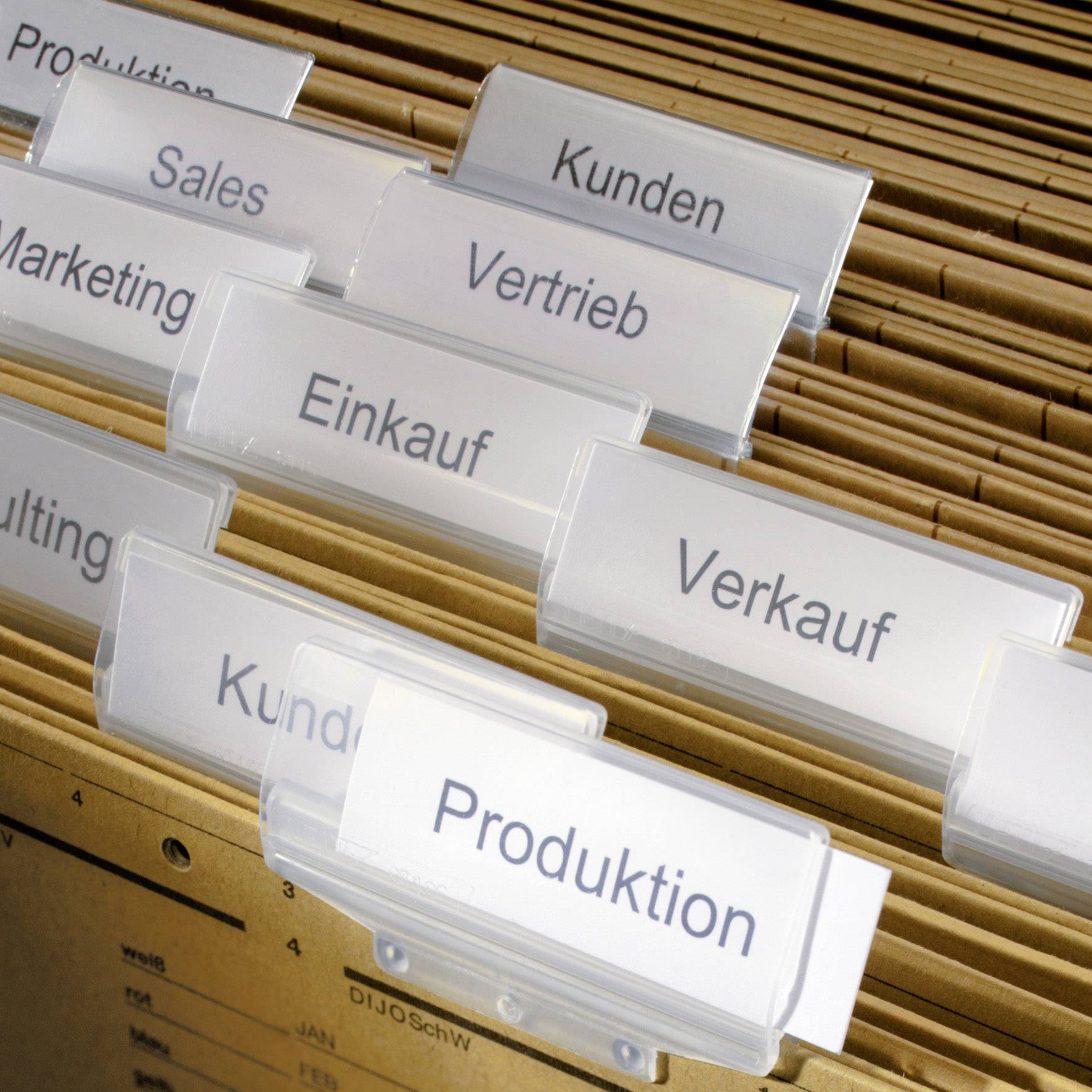 Registrační šanony v skříni označené štítky 'Zákazníci', 'Prodej', 'Výroba', 'Nákup', 'Odbyt', 'Sales', 'Marketing', 'Poradenství'.
