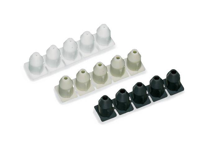 Bílé a černé kuželovité čepy na dvou nosničích.