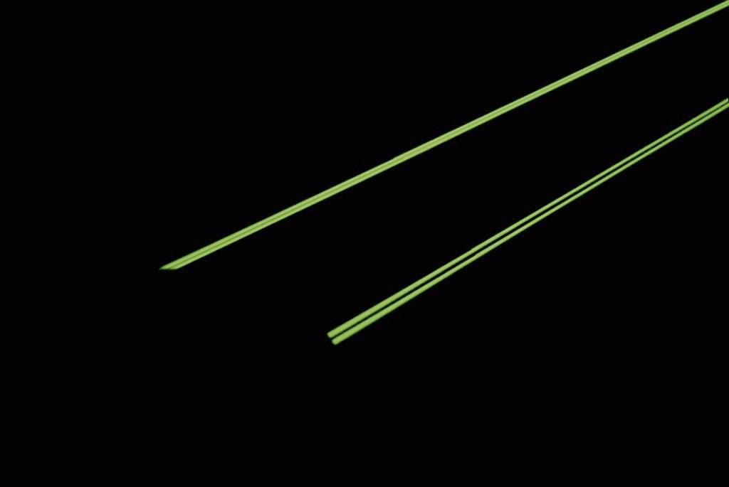 Dva zářivě zelené laserové paprsky v tmavém prostředí, probíhající souběžně.