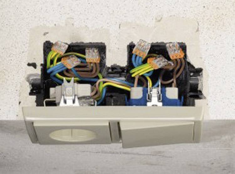 Otevřená elektrická zásuvka se viditelnými barevnými kabely a svorkami na stěně.