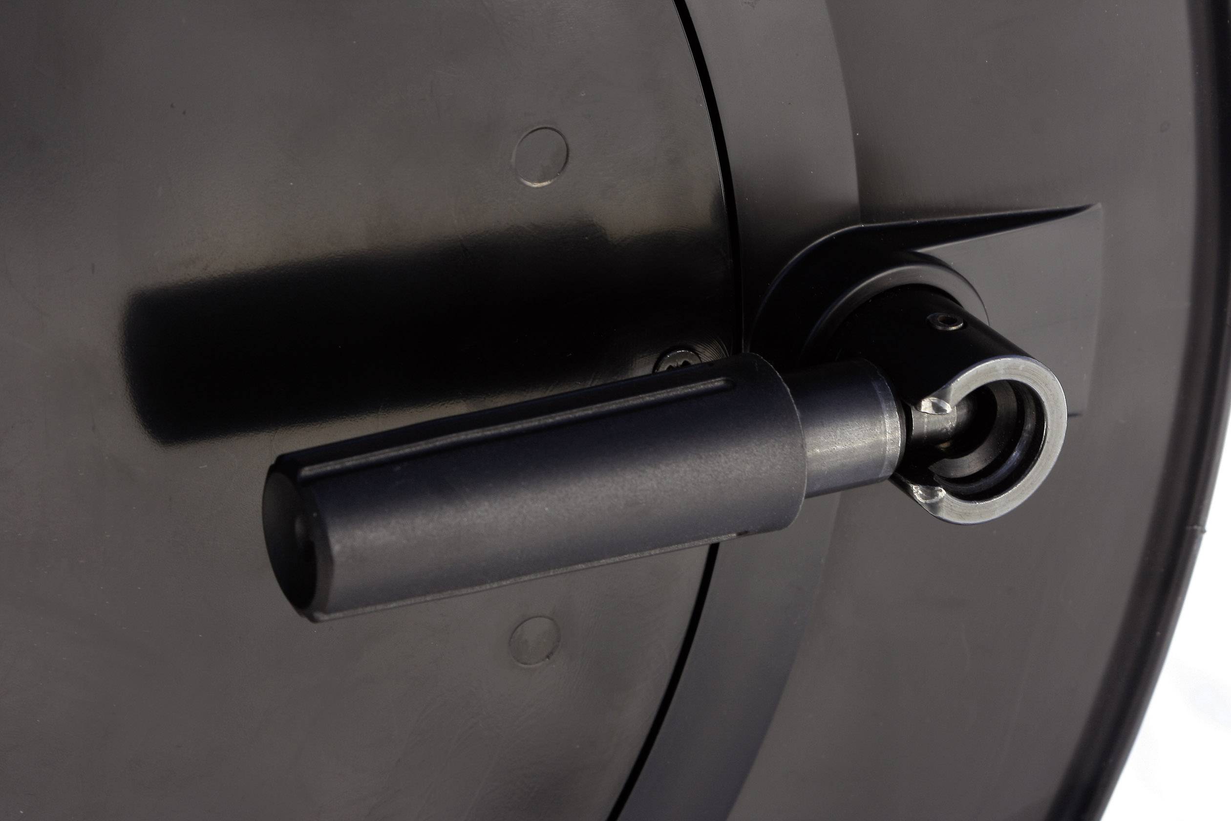 Černý, válcový předmět s držákem a mechanickým detailem, pravděpodobně součást většího zařízení nebo mechanismu.