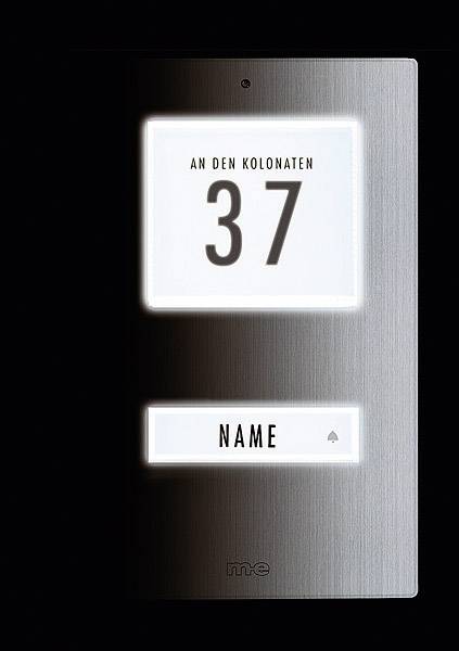 Cedule na dveřích s nápisem 'An den Kolonaten 37'. Pod ní jmenovka s místem pro osobní jméno nebo poznámku.