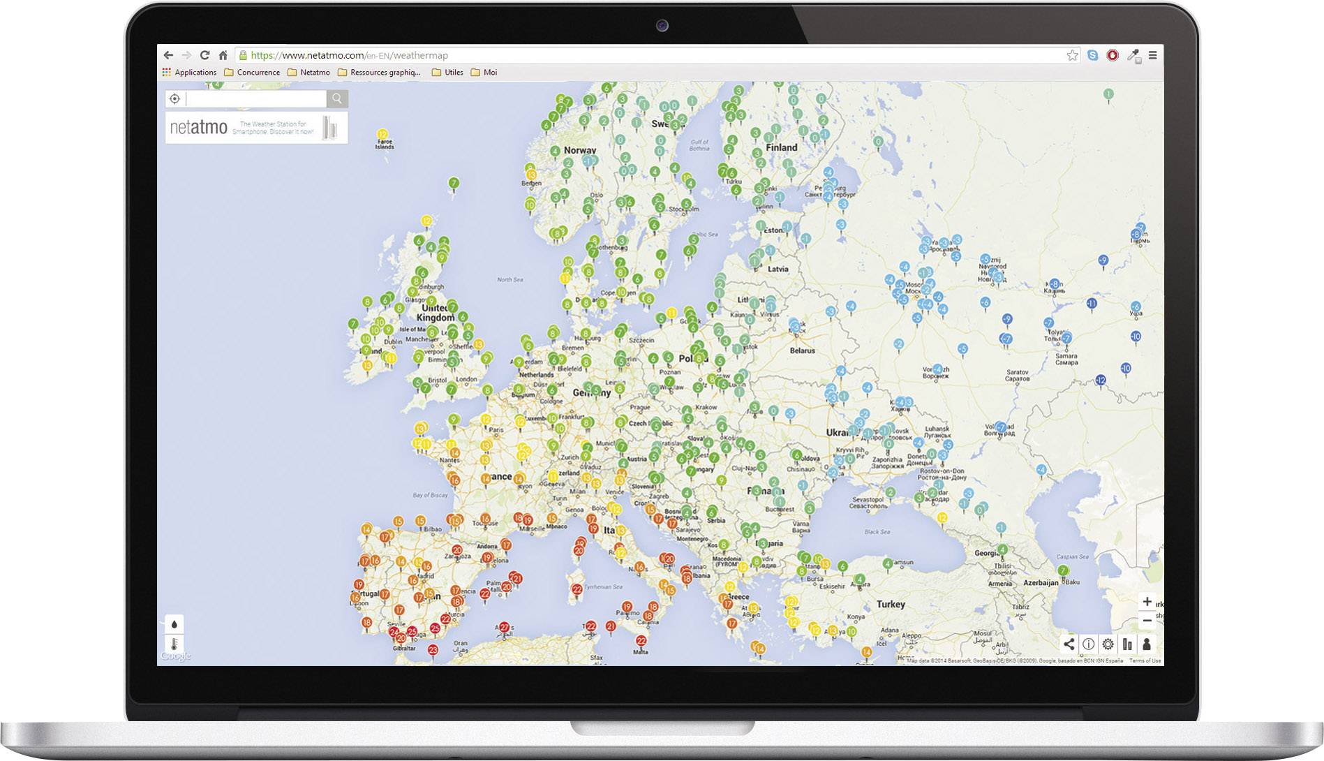 Mapa Evropy na obrazovce laptopku, zobrazující barevně kódované značky v různých zemích pro meteorologické stanice nebo podobná data.