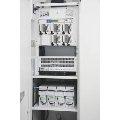 Otevřená serverová skříň s několika technickými zařízeními, jako jsou router, síťové karty a napájecí jednotky.