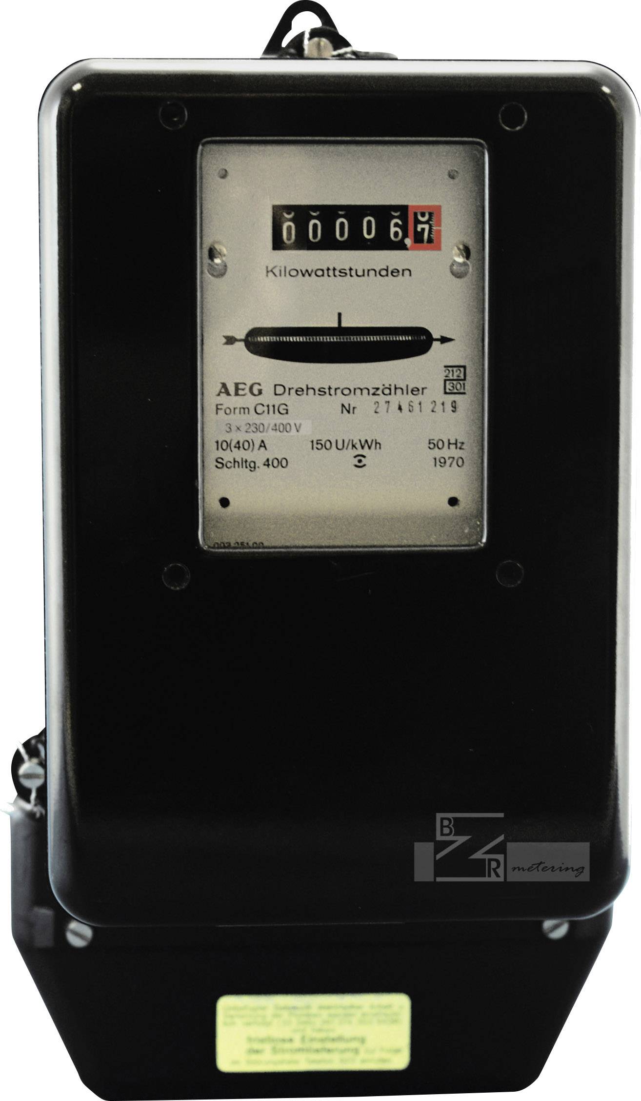 Analogový elektroměr s číselníkem ukazuje 69 kilowatthodin. Nápis 'AEG třífázový elektroměr' a technické detaily.