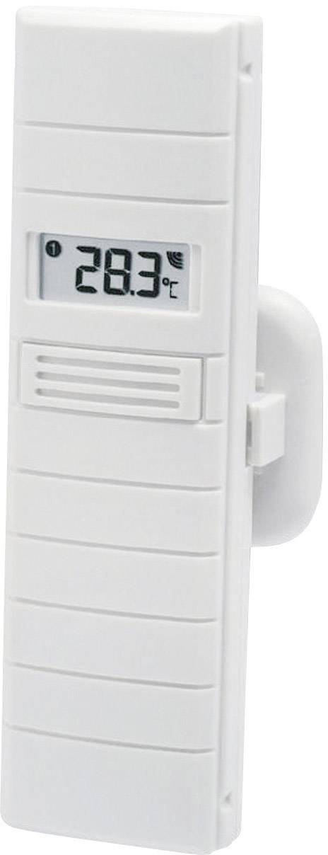 Digitální teploměr ukazuje teplotu 28,3°C. Je namontován v bílém pouzdře a visí na stěně.