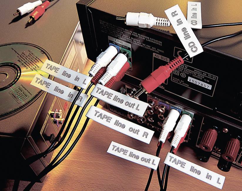 Zadní strana audio zařízení s několika připojenými kabely. Každý kabel je označen štítky jako 'TAPE line in' a 'CD line in'.
