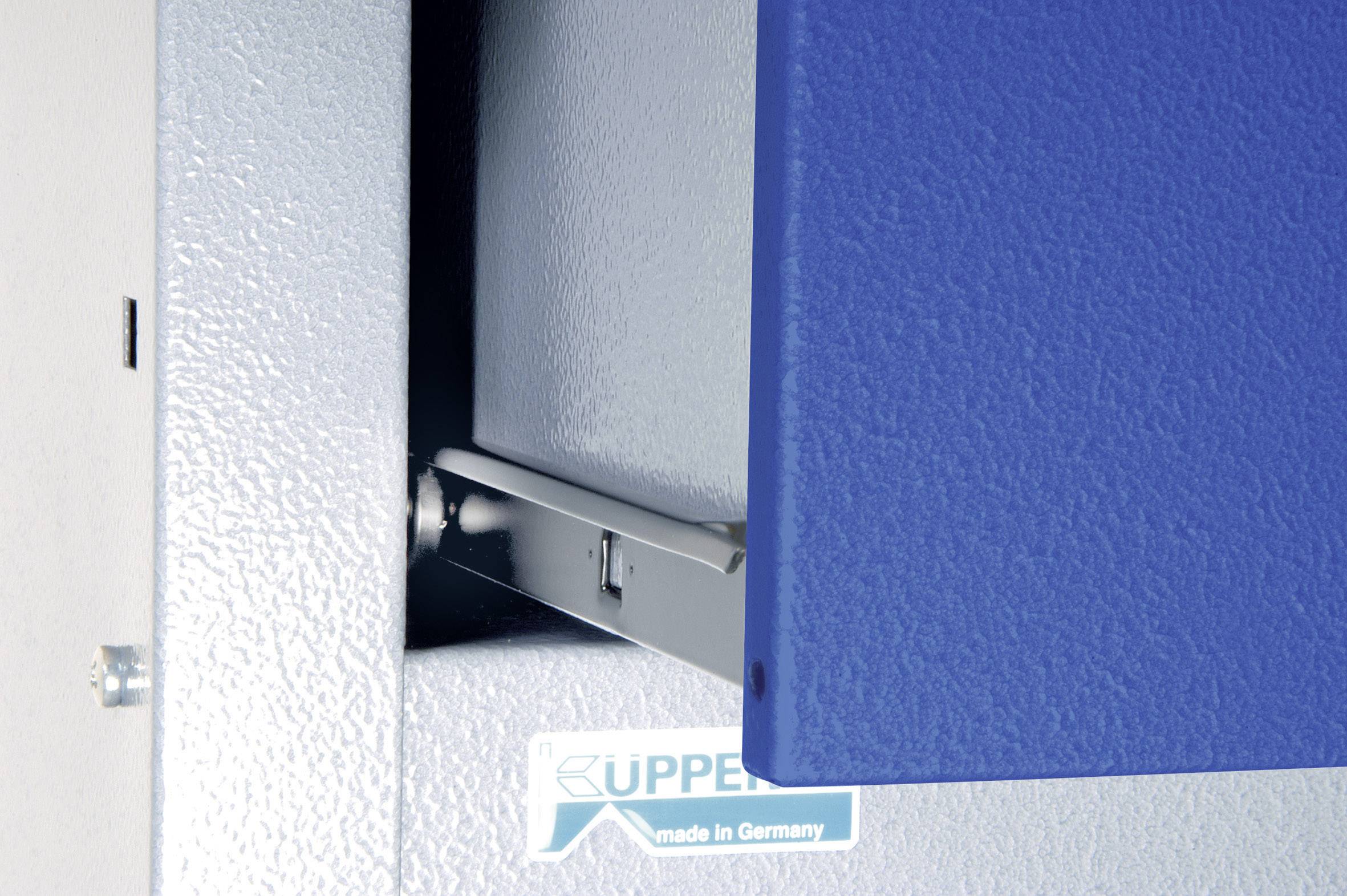 Detailní záběr modrého pantu na kovovых dveřích s nápisem "Made in Germany".