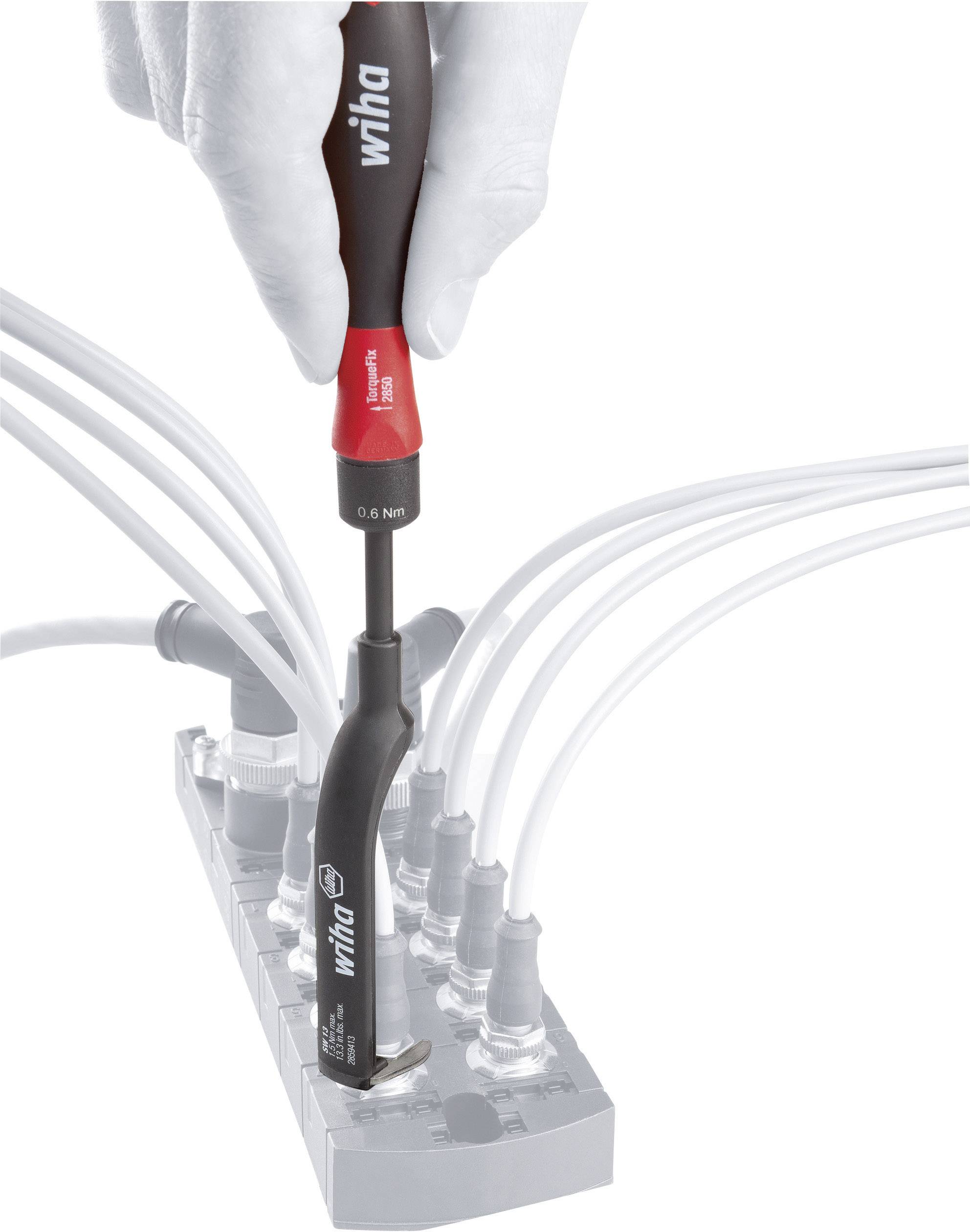 Jedna ruka používá momentový šroubovák Wiha k utažení kabelů na svorkovnici.