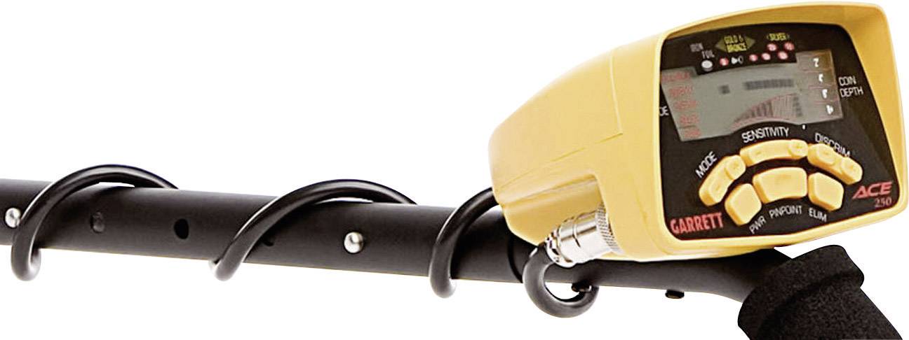 Žlutý kovový detektor s digitálním displejem a několika nastavovacími tlačítky, upevněný na černé rukojeti.
