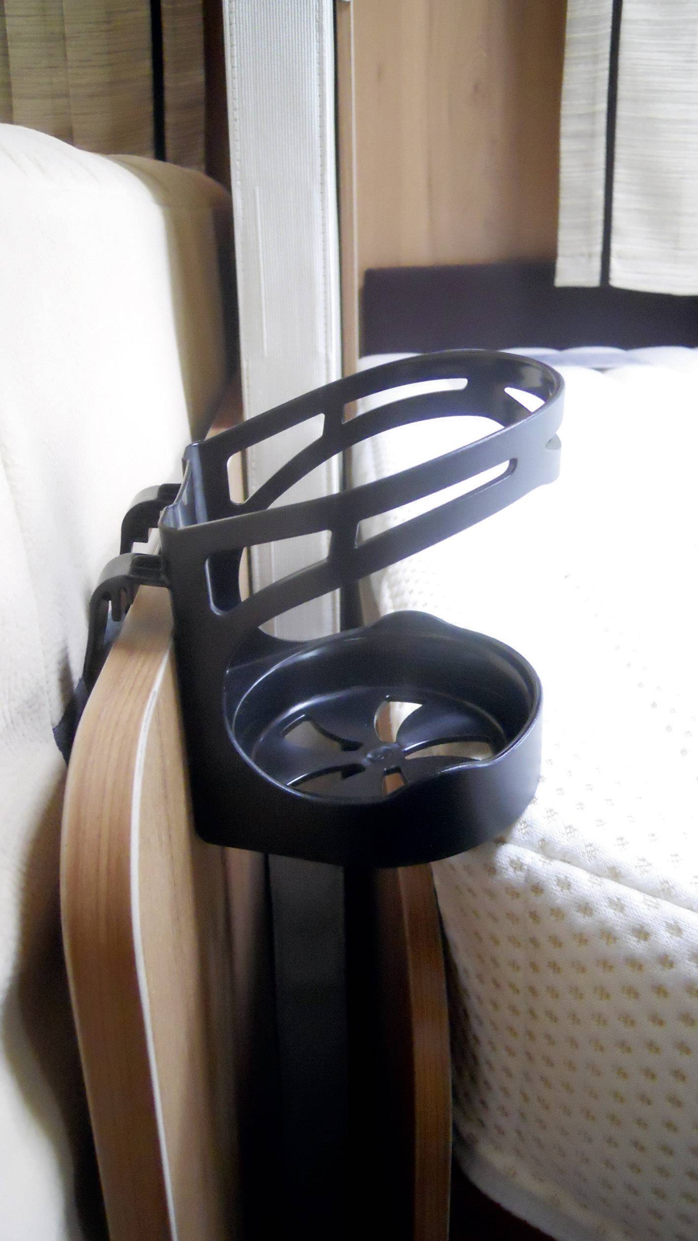Černý držák nápojů je připevněn k opěrce křesla.