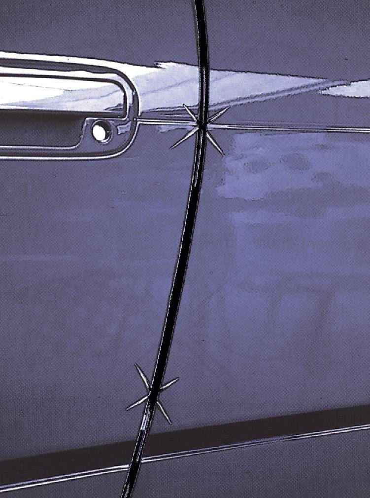 Detailní záběr autových dveří s poškozeným lakem, skrz který je vidět kov. Dveře mají viditelnou kliku v horní levé části.