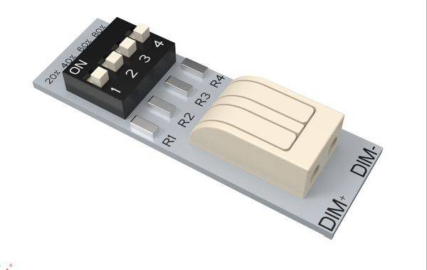Malý elektrický spínač se čtyřmi očíslovanými pákovými přepínači (1-4) na obdélníkovém modulu, s popisy 'R1, R2, R3, R4' a 'DIM+, DIM-'.