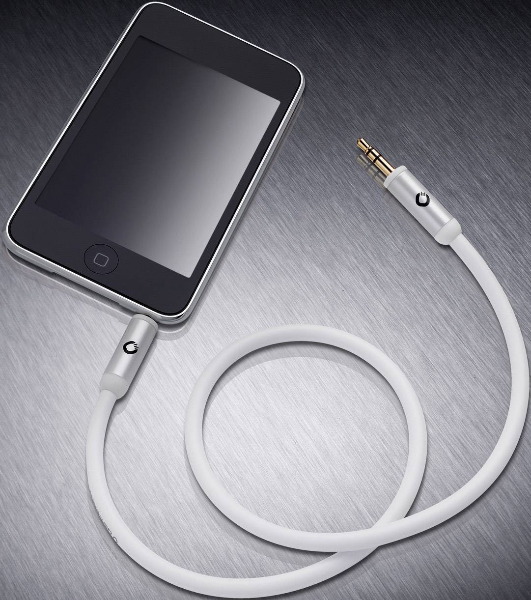 Černý smartphone s kulatým tlačítkem leží na šedém kovovém povrchu. Je připojen bílým audio kabelem.