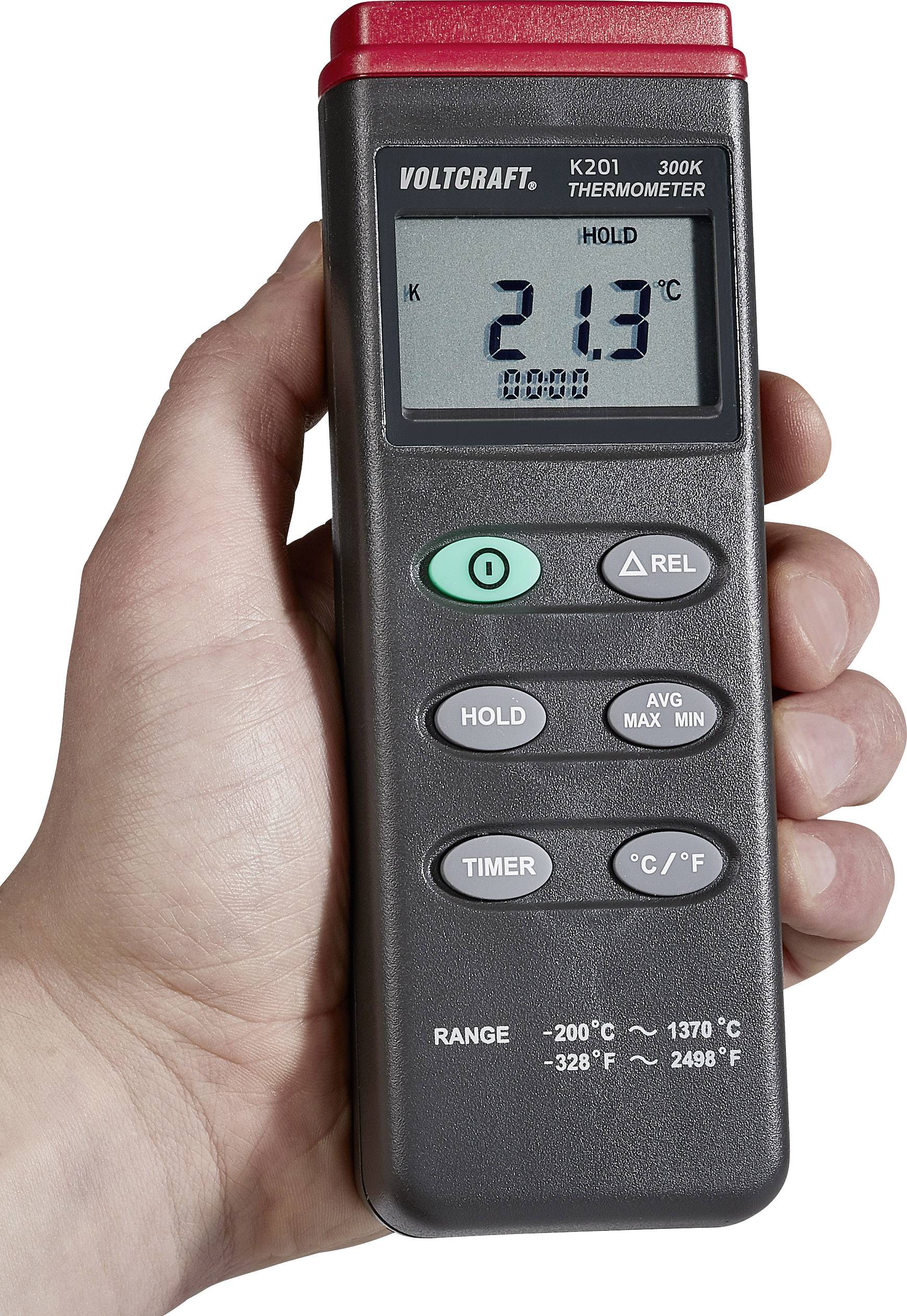 En hånd holder et elektronisk termometer fra Voltcraft. Displayet viser 21,3°C. Taster til Hold, Timer, Gennemsnit, Maks, Min og enhedsskift.