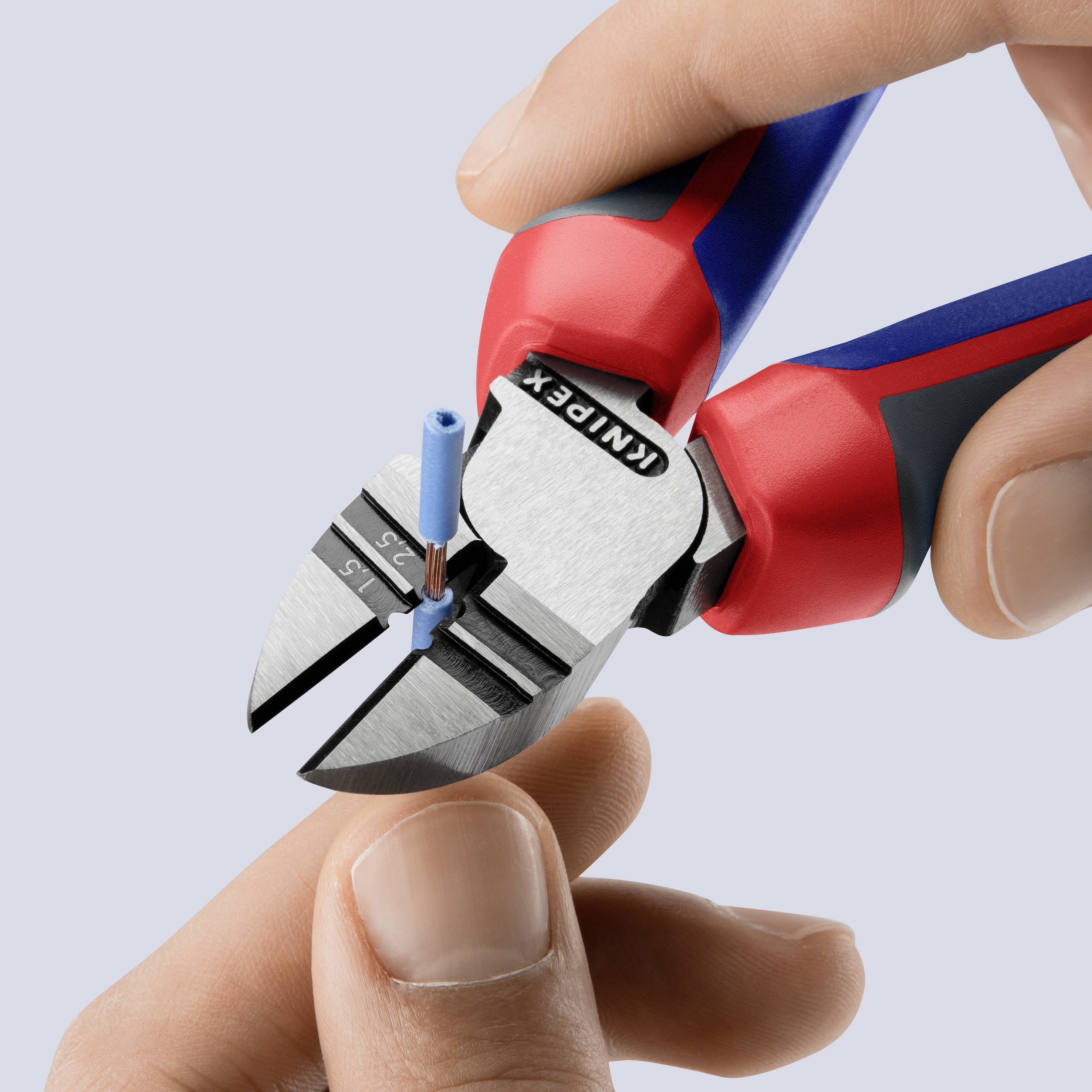 En hånd holder en Knipex afisoleringstang, der afisolerer et blåt kabel. Værktøjet ses i nærbillede.