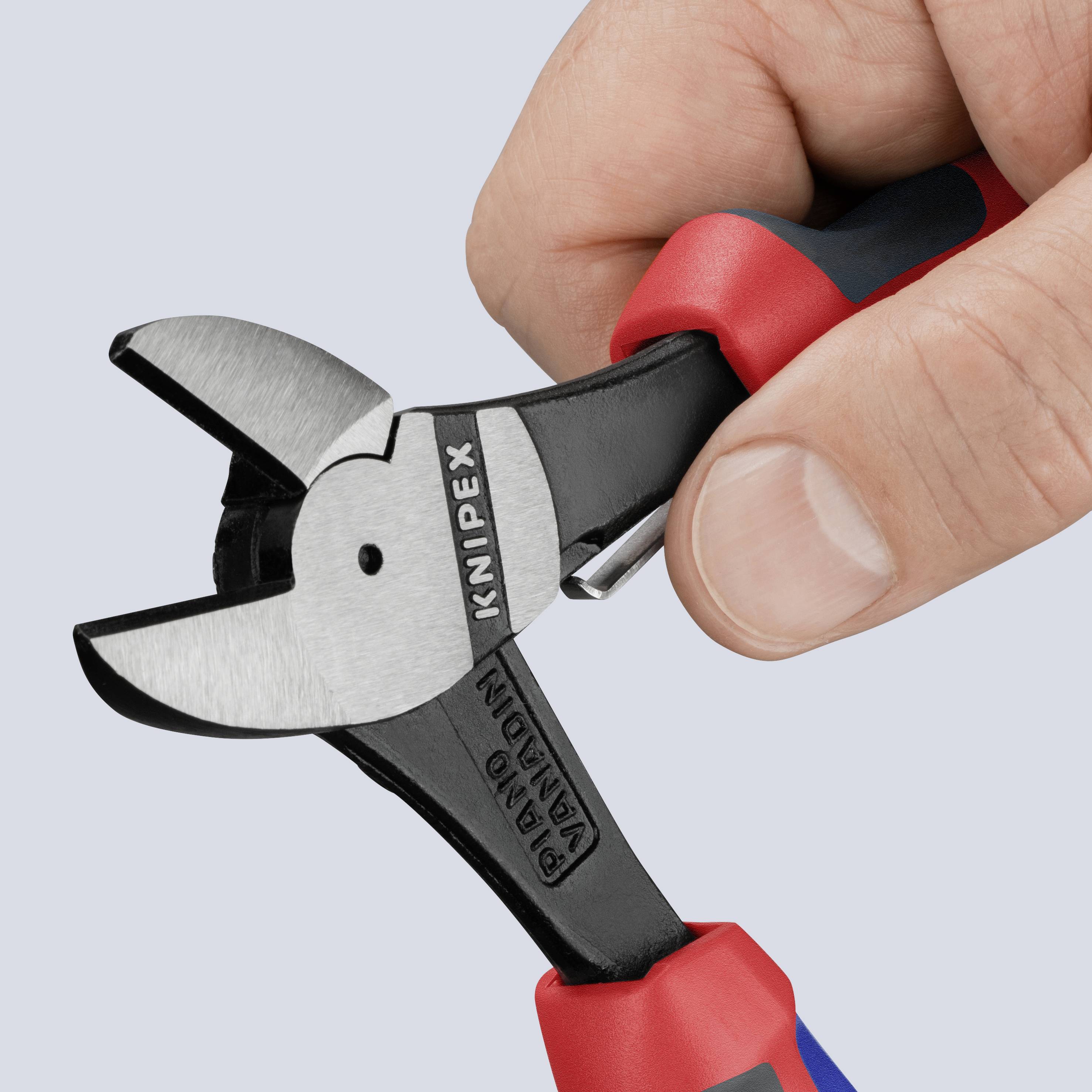 En hånd holder en Knipex-sideskærer med røde og blå greb, velegnet til præcis skæring af ledninger og kabler.