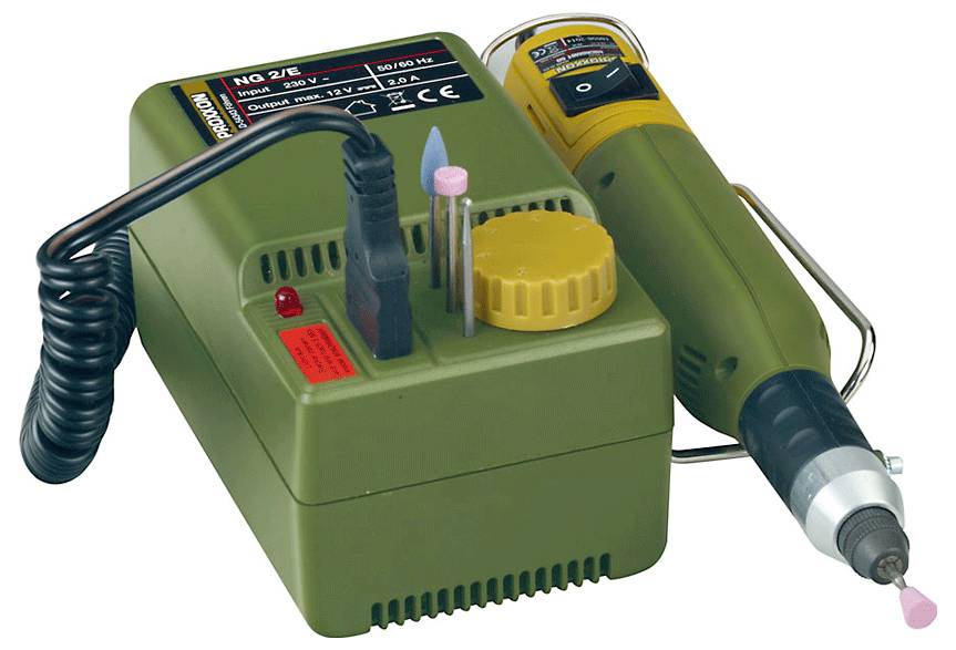 'Proxxon Micromot 50/EF' drejetool og strømforsyning med tilbehør, herunder en blå flamme, en pink slibespids og graverspidser.