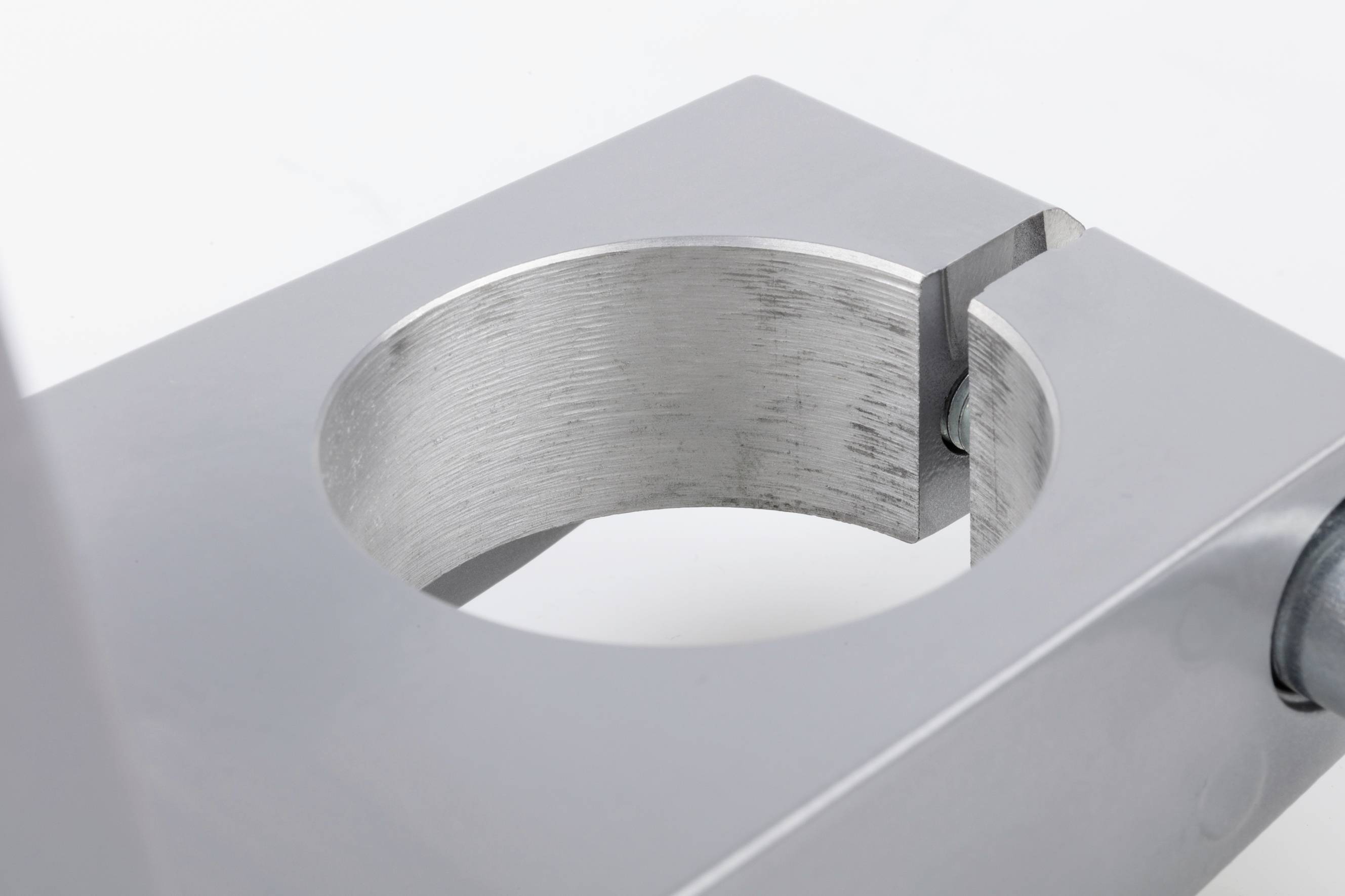 Metalklemmer med cirkulær åbning, egnet til fastgørelse af cylindriske objekter. Højglanspoleret overflade.