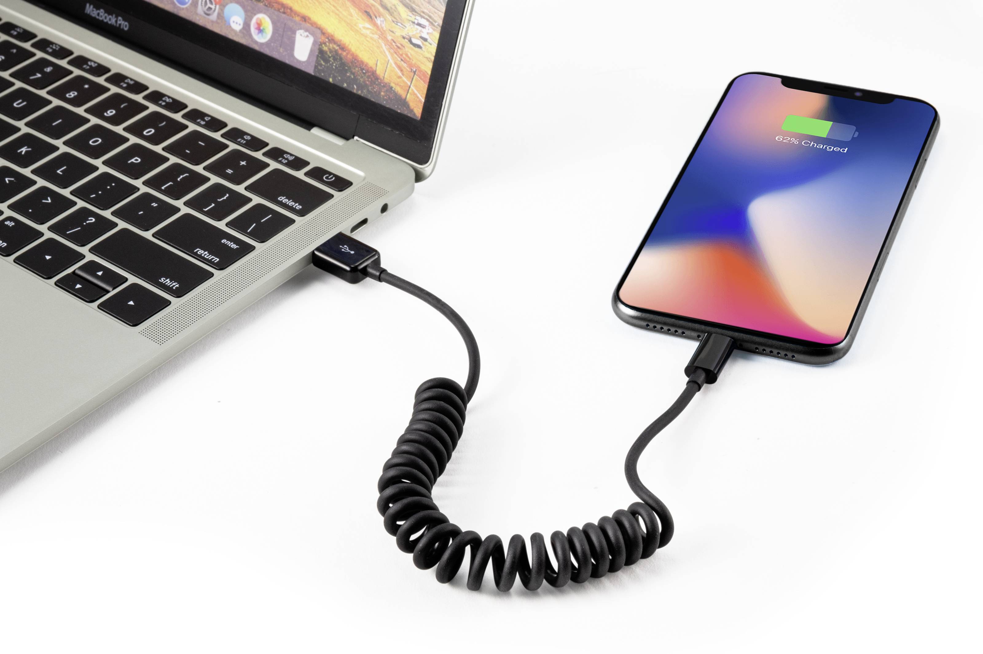 En laptop er forbundet med en smartphone, som bliver opladet. På smartphonens skærm står der '100% opladet'.