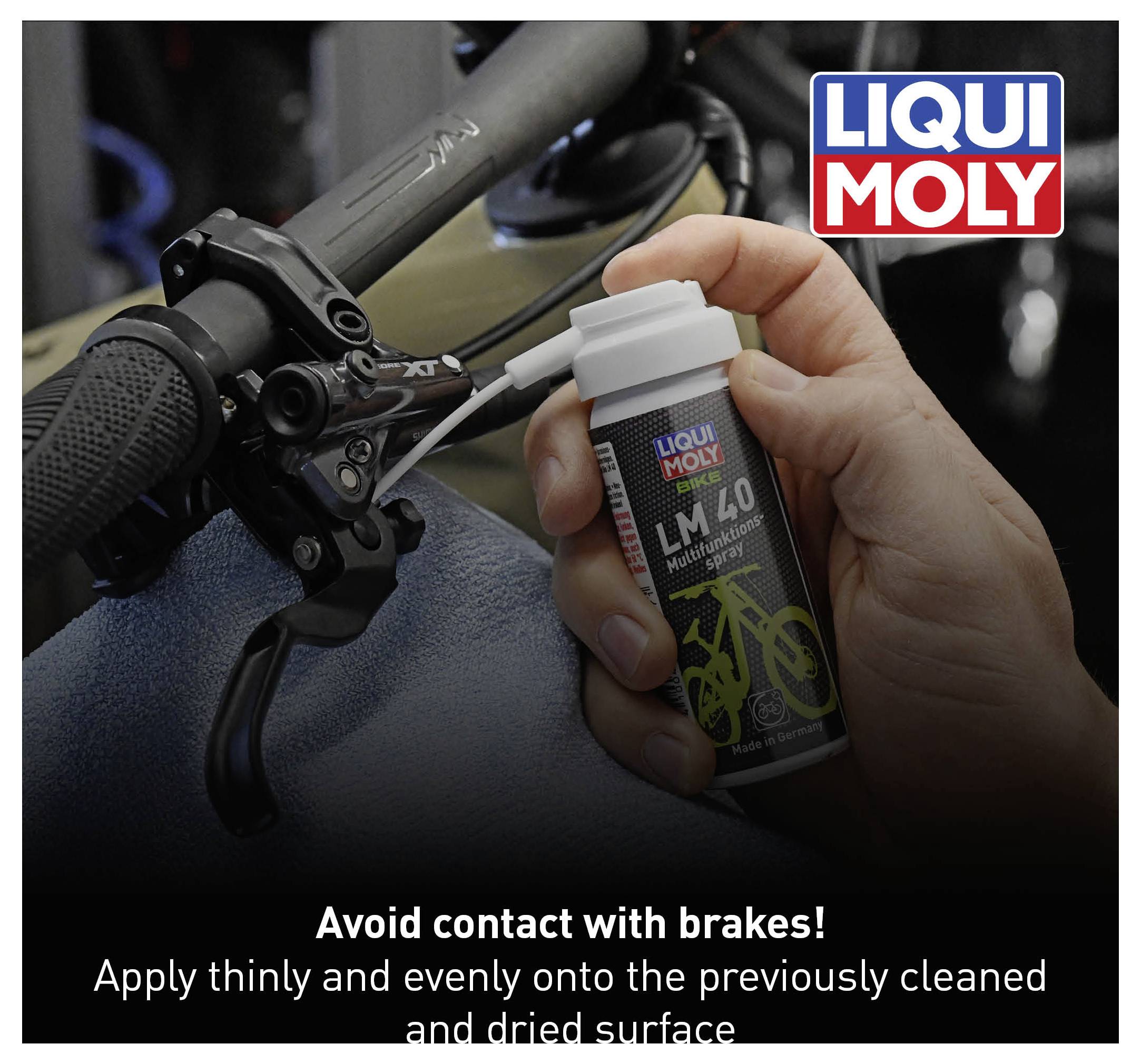 Flaske med Liqui Moly LM 40 sprayes på cykelstyr. Tekst: 'Undgå kontakt med bremser! Påfør et tyndt lag på rengjort, tør overflade.'