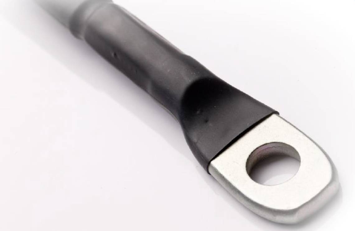 En metalring-kabelsko med plastisk isolering, egnet til elektriske forbindelser, ligger på en hvid overflade.