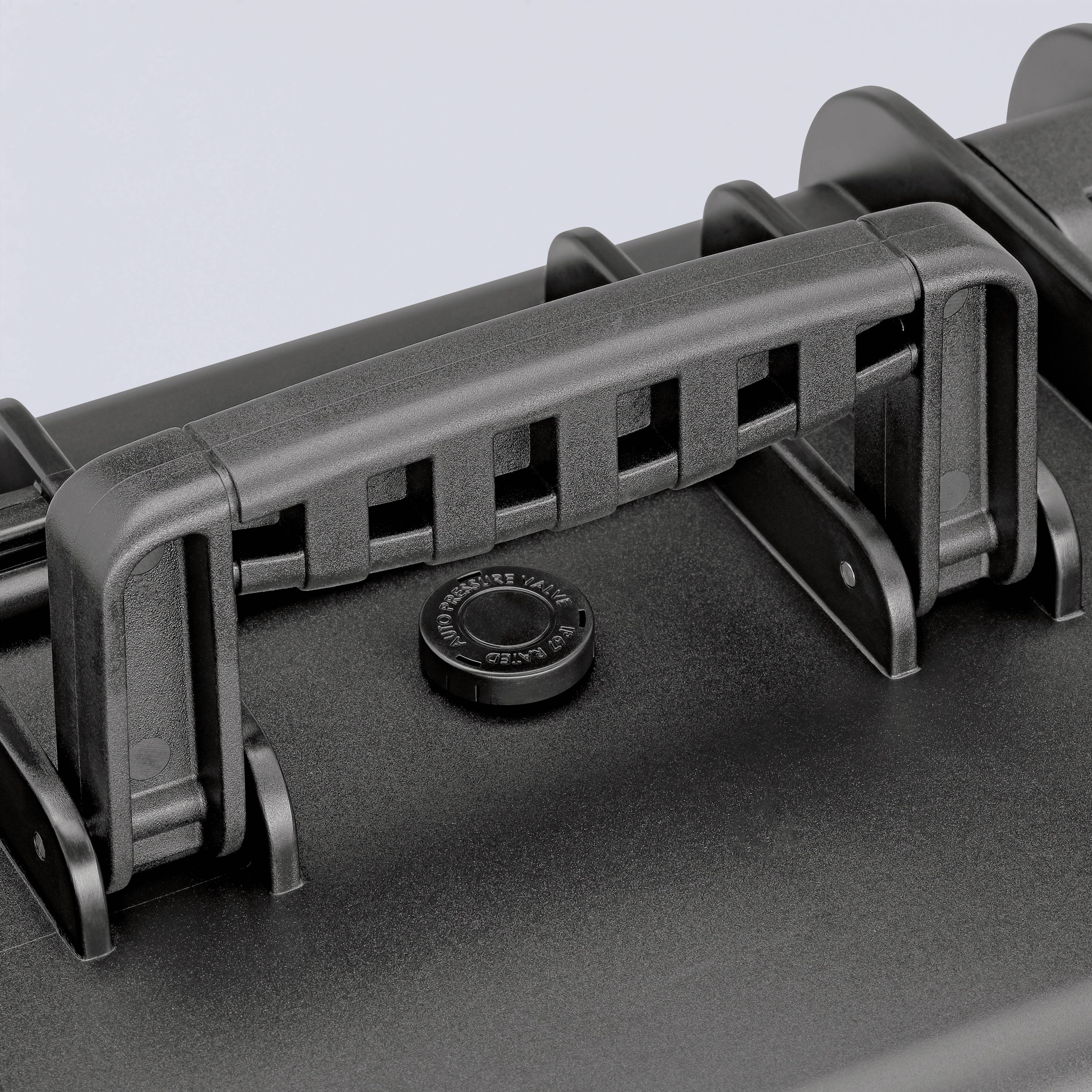 Et sort kuffertgreb på en hardcase-kuffert. Grebet er robust og sammenklappelig, velegnet til sikker transport.