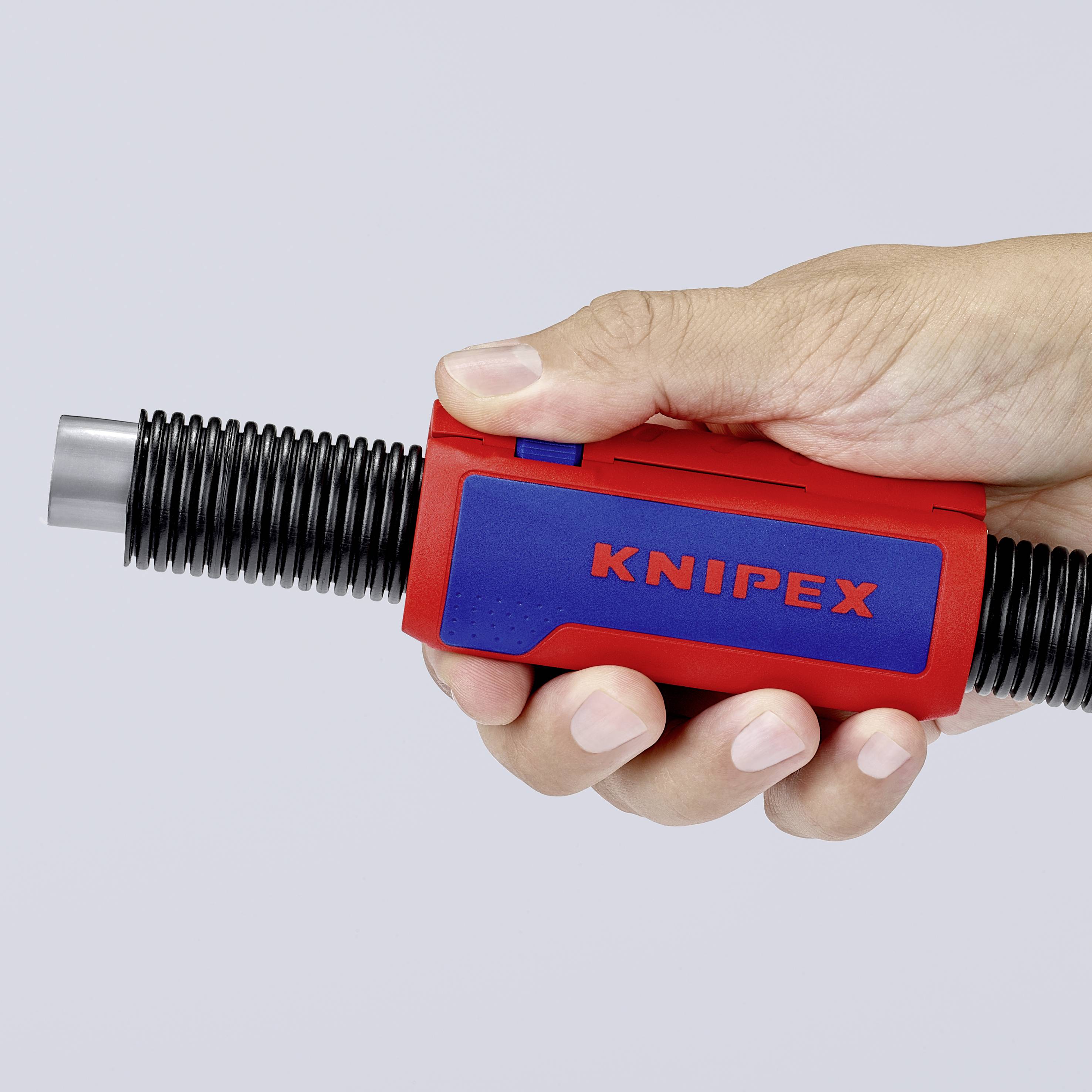 Hånd holder KNIPEX-værktøj, rød-blå, med riflet sorte spidser.Værktøjet er lukket.