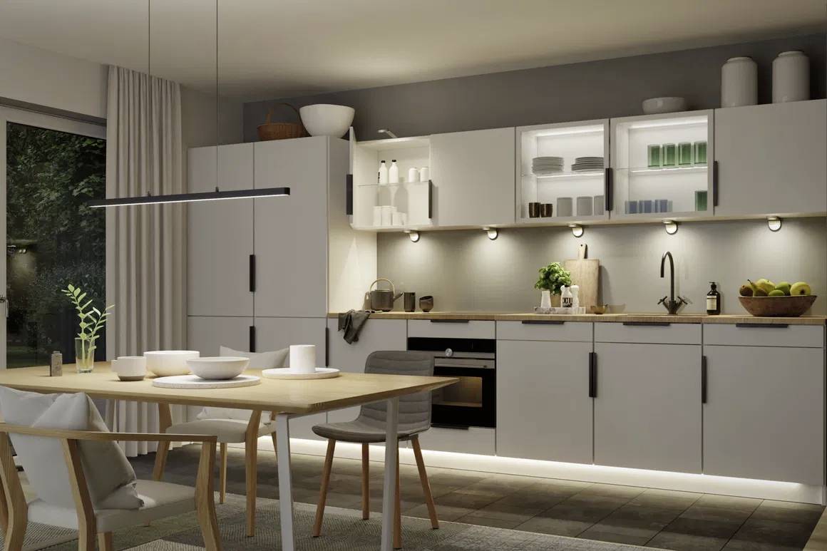 Moderne køkken med spisebordet, lyse skabe og belysning, åben reol med service, vindue med gardin, træ- og metaldetaljer.