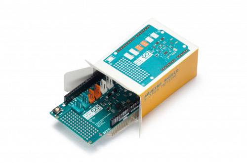 Et Arduino-board, delvist trukket ud af en orange-hvid emballage, viser tilslutninger og kredsløb.