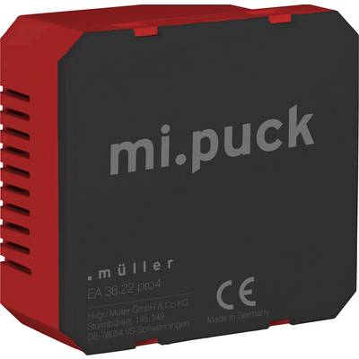 Roterende, kvadratisk teknisk adapter med påskriften 'mi.puck' og CE-mærkning. Produceret af Hugo Müller GmbH & Co KG i Tyskland.