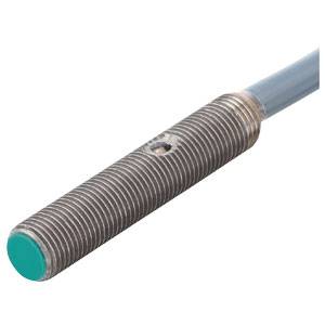 En cylindrisk induktiv sensor med riflet metaloverflade og grøn ende, forbundet med et kabel.