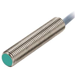 Cylindrisk sensor med riflet metaloverflade og grønt endestykke, forbundet med et kabel. Elektronisk komponent.
