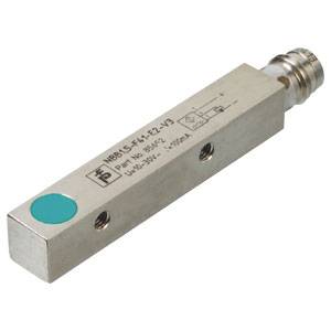 Metallisk rektangulær sensor med grøn markering og tilslutninger, muligvis til registrering af position eller bevægelse i industrielle applikationer.