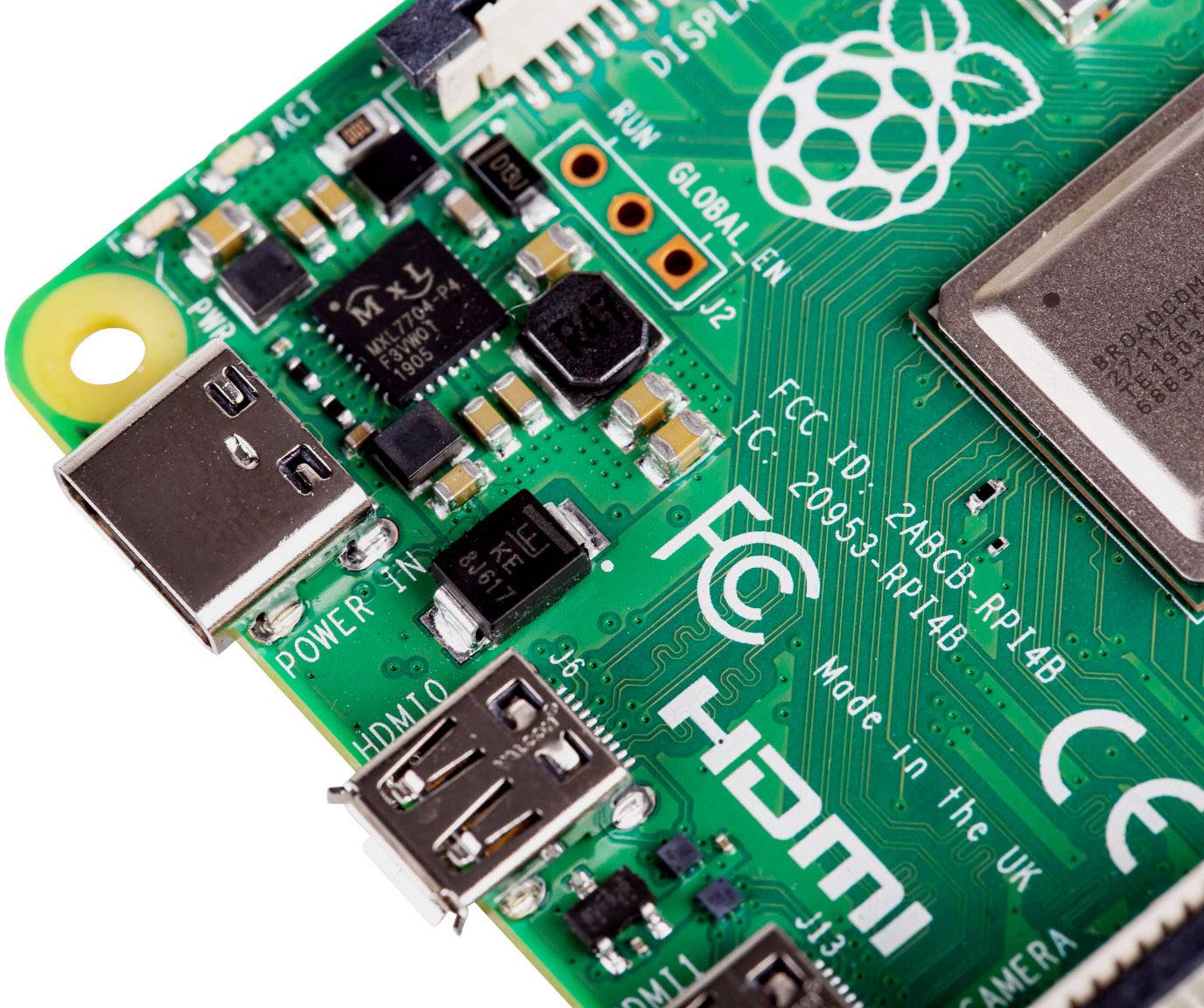 Nærbillede af et grønt printplade med USB- og HDMI-tilslutninger. Øverst til venstre et Raspberry Pi-logo. Tekst på printpladen: 'FCC ID: 2ABCB-RPI4B'.