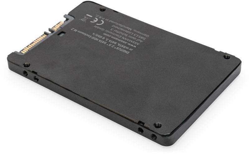 En sort SSD-harddisk med SATA-forbindelse, liggende på en hvid overflade.