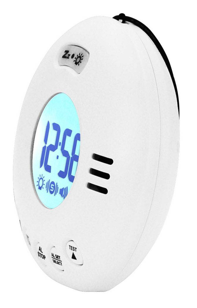 En oval digital vækkeur med blå baggrundsbelyst display viser "12:58". På urets kabinet er der knapper til alarmfunktioner og test.