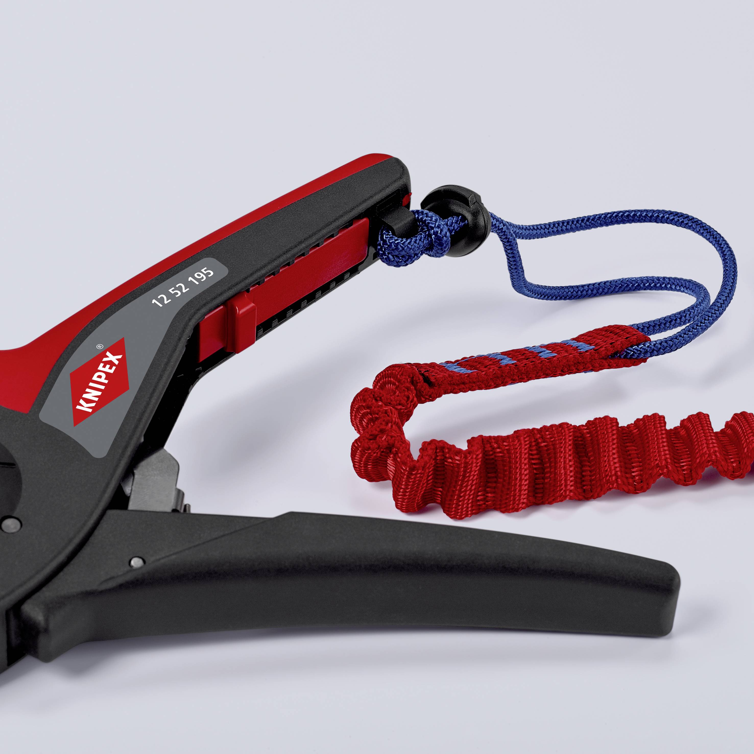 En tang med rødt håndtag og påskrift 'KNIPEX'. Fastgjort er et blå-rødt sikkerhedsbånd, som forhindrer fald.